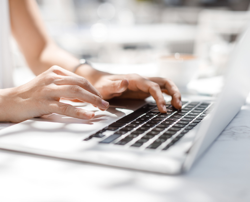 Side View Of Hands Typing On A Keyboard