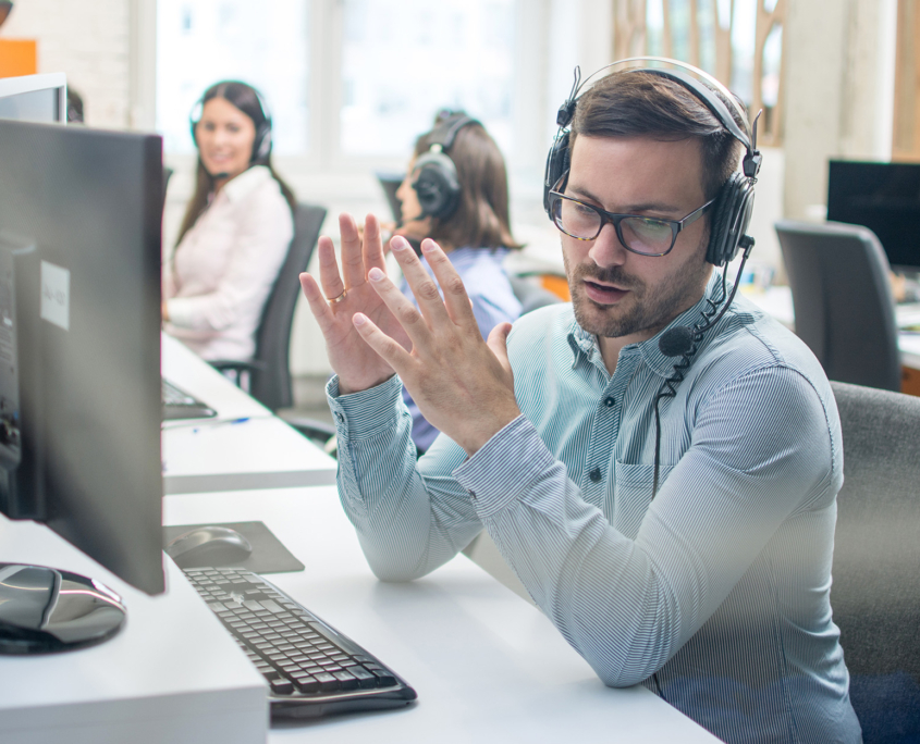 Young Handsome Male Technical Support Agent Trying To Explain Something To A Client